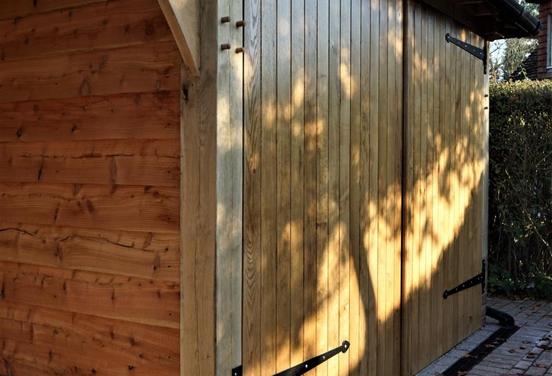 Curved oak braces, iron T hinges, oak garage doors - all handmade
